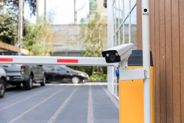 Security CCTV camera surveillance system outdoor of carpark. A blurred night city scape background. Modern CCTV camera on a wall. Equipment system service for safety life or asset.