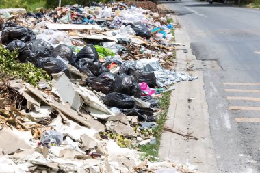Ev içi çöp yığını. Bir sürü plastik torba, şişe ve diğer atıklarla dolu bir çöp yığını. Sokakta bir sürü çöp var..