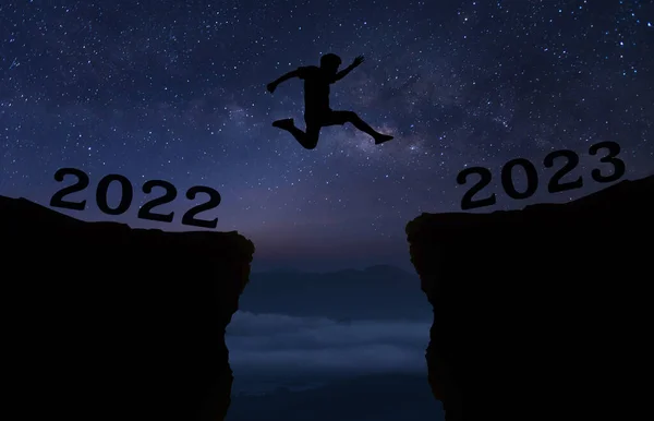2022年至2023年间 一个年轻人带着星星跳过夜空 穿过山丘轮廓的缝隙 看到了夜晚五彩斑斓的天空 新的一年2022 银河路 — 图库照片