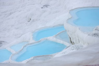 Pamukkale 'deki doğal travertin havuzları ve terasları. Türkiye 'nin güneybatısındaki pamuk kale. Pamukkale traverteni ve antik Hierapolis şehri. Pamukkale 'deki turkuaz su travertin havuzları