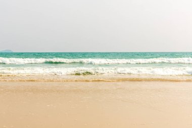 Tropik plaj yaz tatili için doğal arka plan. Turkuaz okyanus suyu ve güneşli bir günde bulutlu mavi gökyüzü. Beyaz kumlu güzel bir sahil.. 