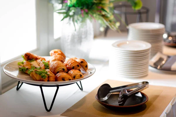 Lokanta büfesi yemek masasında çikolatalı çörek. Yemek masasında leziz yemekler var. Düğünde bir yığın kruvasan sandviçi