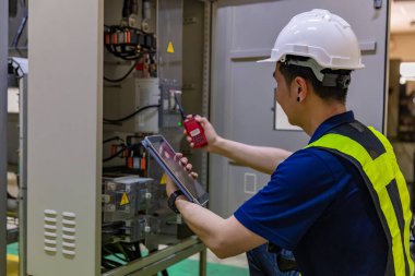 Termal kamerayla fotovoltaik modüllerin incelenmesi. Mühendis Sıcaklığı Denetliyor. Güneş panelini ters çevirmek için kullanılan sicim kabloları girdisi.