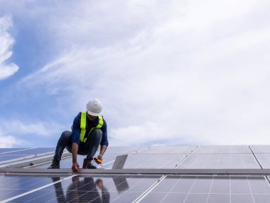 Fabrikanın çatısındaki güneş pilini kontrol et. Çatıda yürüyen mühendisler güneş pili panelini inceleyip kontrol ediyorlar. Çatıda çalışan mühendis teftiş kurulum güneş hücresi