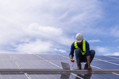 Fabrikanın çatısındaki güneş pilini kontrol et. Çatıda yürüyen mühendisler güneş pili panelini inceleyip kontrol ediyorlar. Çatıda çalışan mühendis teftiş kurulum güneş hücresi