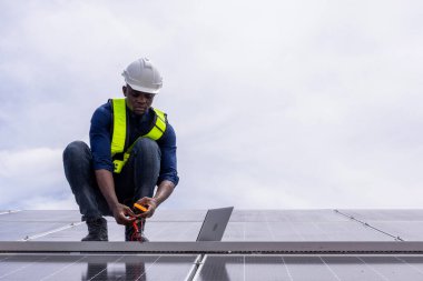 Fabrikanın çatısındaki güneş pilini kontrol et. Çatıda yürüyen mühendisler güneş pili panelini inceleyip kontrol ediyorlar. Çatıda çalışan mühendis teftiş kurulum güneş hücresi