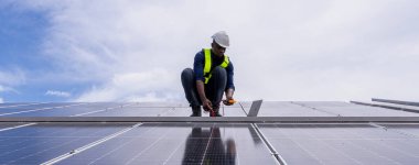 Fabrikanın çatısındaki güneş pilini kontrol et. Çatıda yürüyen mühendisler güneş pili panelini inceleyip kontrol ediyorlar. Çatıda çalışan mühendis teftiş kurulum güneş hücresi