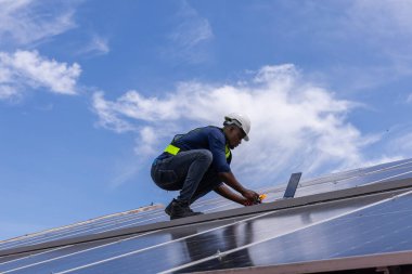 Fabrikanın çatısındaki güneş pilini kontrol et. Çatıda yürüyen mühendisler güneş pili panelini inceleyip kontrol ediyorlar. Çatıda çalışan mühendis teftiş kurulum güneş hücresi