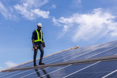 Fabrikanın çatısındaki güneş pilini kontrol et. Çatıda yürüyen mühendisler güneş pili panelini inceleyip kontrol ediyorlar. Çatıda çalışan mühendis teftiş kurulum güneş hücresi