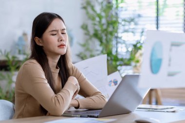 İş kadını, iş başarısız olduğunda evrakları üzerine attığı için kızgın. Ofiste dizüstü bilgisayarla çalışan ciddi bir kadın.