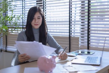 Modern ofisteki iş verilerini hesaplamak için hesap makinesi üzerinde çalışan iş kadını ya da muhasebeci. Muhasebeci kadın yatırım verilerini, mali ve vergi sistemleri kavramlarını analiz ediyor.