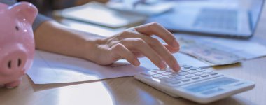 Modern ofisteki iş verilerini hesaplamak için hesap makinesi üzerinde çalışan iş kadını ya da muhasebeci. Muhasebeci kadın yatırım verilerini, mali ve vergi sistemleri kavramlarını analiz ediyor.