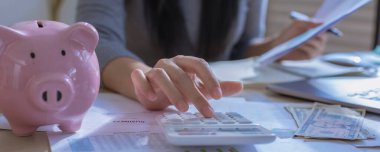 Modern ofisteki iş verilerini hesaplamak için hesap makinesi üzerinde çalışan iş kadını ya da muhasebeci. Muhasebeci kadın yatırım verilerini, mali ve vergi sistemleri kavramlarını analiz ediyor.