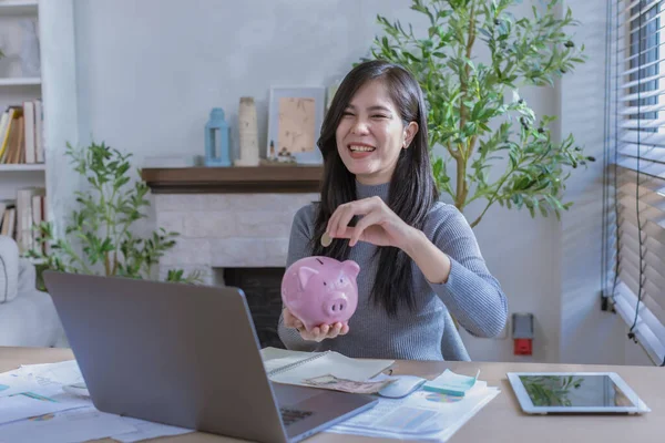 Kadın ev konseptinden çalışıyor. Muhasebe için para biriktiriyor. Tasarruf parası zenginlik kavramı, Asyalı iş kadını el yazısı yönetim bütçesi tasarruf maliyeti, nakit finans