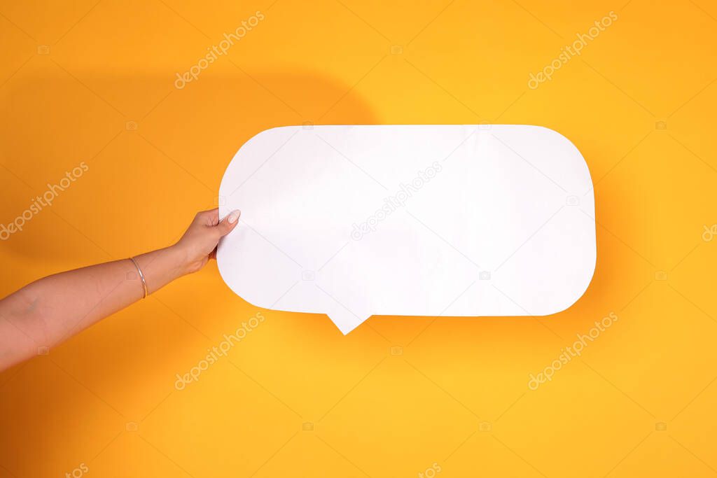 Female hand with blank speech bubbles on color background. isolated on yellow. Empty space for text