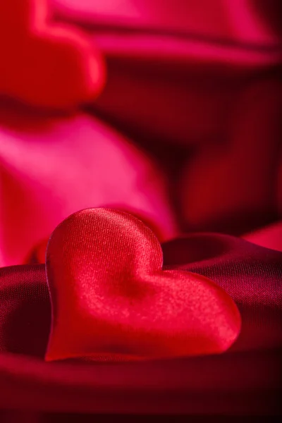 Red heart Valentine's Day symbols on red silk background close up — Stock Photo, Image