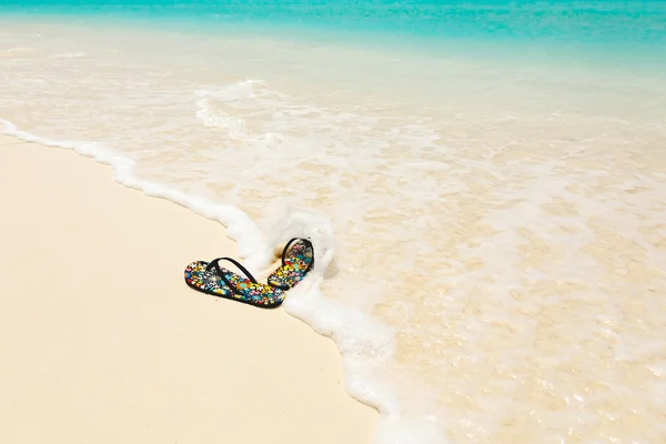 Farbige Sandalen am Strand — Stockfoto