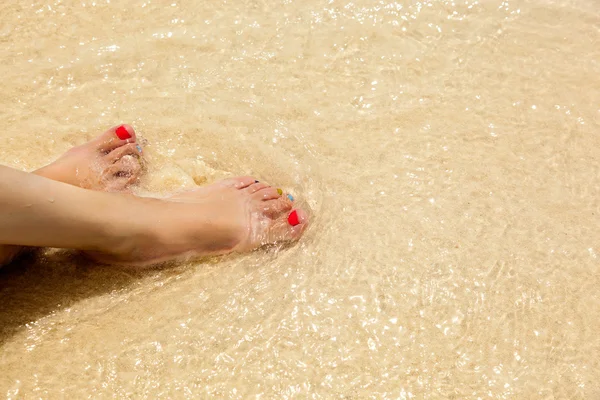 Slanke benen op het strand — Stockfoto