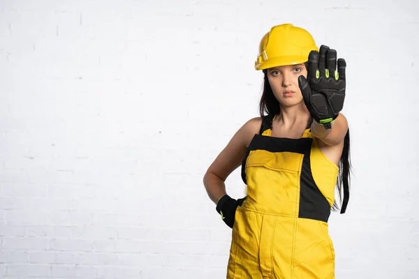 Um jovem trabalhador da construção civil mostra claramente que você não pode chegar perto deste lugar. Saúde e Segurança no Trabalho. Ordem de restrição. Pare!. — Fotografia de Stock