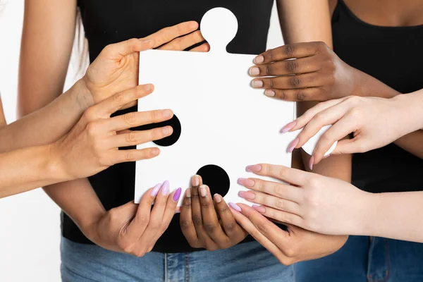 Huit mains féminines de nationalités et de races différentes sur un bloc de puzzle. Symbole de réconciliation de la teinture et de l'appariement social. — Photo