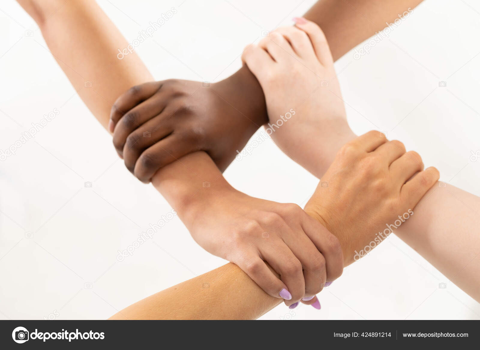 Each of the four hands is clasped around the friends wrist. One hand grips  the other, and so on. Young girls hands. Stock Photo by ©info.fotodrobik.pl  424891214