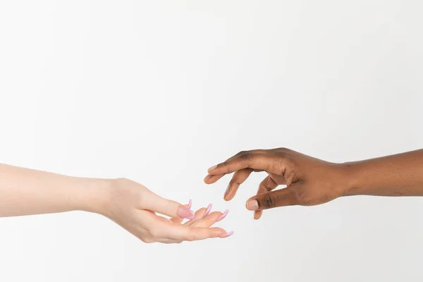 Una mano de ayuda extendida para dar apoyo. Dos manos acercándose. Manos de dos razas, africana y europea, atrayéndose entre sí. — Foto de Stock