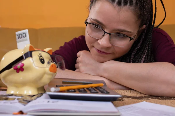 The smartest couple in the field of home finance, a young adult and her porcelain piggy bank. Free time devoted to learning about running a household budget.