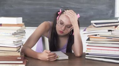 Okul kütüphanesinde, genç birçok kitap arasından birini seçti ve onu okumaya başladı. Uzun koyu renk saçları vardı. Okumakla ilgileniyor..