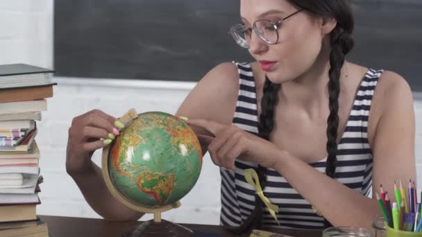 Aardrijkskundeles. Een tiener kijkt naar de wereld en zoekt een plek waar ze de volgende vakantie wil doorbrengen en een pauze wil nemen van haar studie.. — Stockvideo