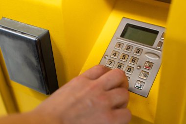 Kız paketin şifresini parsel makinesine girerek numaralandırıyor. Otomatik bir makine ile iletişim klavyesi.