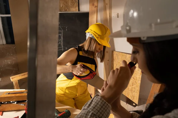 Dos niñas comienzan en el taller preparando las herramientas para comenzar la jornada de trabajo en el sitio de construcción. Herramientas de carpintería. — Foto de Stock