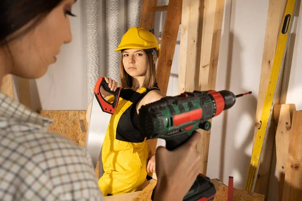 Niñas jóvenes adultas están entre los elementos de madera, con ropa protectora y cascos. — Foto de Stock