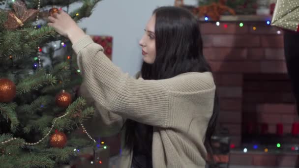 Při zdobení vánočního stromečku se snoubenec rozhodl dát dárek svému vyvolenému a nečekat na Vánoce. — Stock video