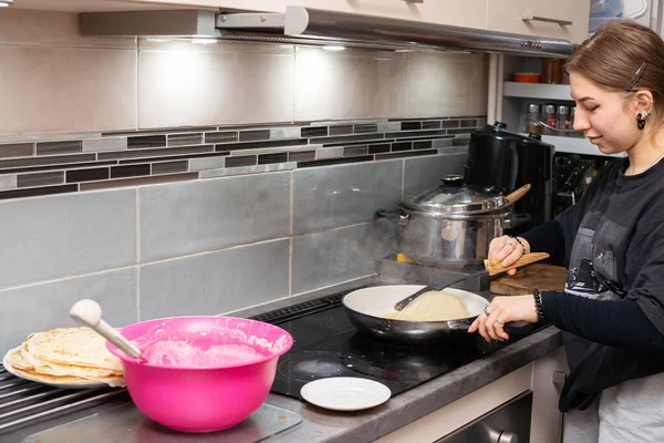 年轻的厨师用厨房里的锅子把煎饼转到另一边。自制煎饼. — 图库照片