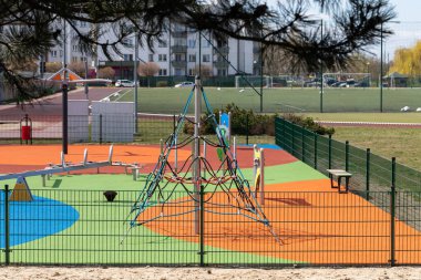 Çocukların oynayacağı bir oyun alanı. Renkli oyun setleri ve güvenli bir yüzey. Kozalaklı kozalaklı ağaç dalı. Çam.