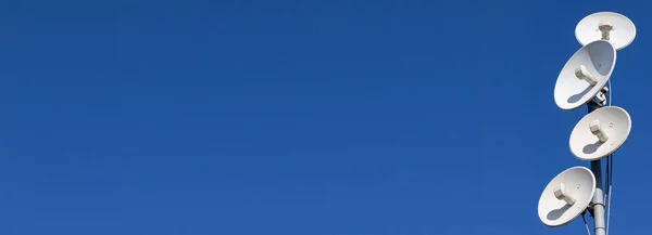 Flera telekommunikationsantenner av ett mobilnät och trådlöst internet mot en blå himmel. Ta emot och digitalisera flera bitar av information på en gång. Panoramaram. — Stockfoto