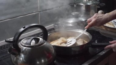 Kızarmış balıkları kızgın yağla ve özel bir kaşıkla tavadan çıkarır, böylece yağlar boşalabilir. Kalın kesilmiş morina parçaları. Ev yemeği..