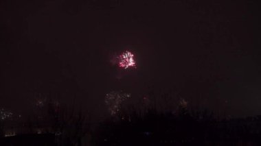 Yeni yılı kutladığımız gün, Lublin 'in panoramasının üzerinde havai fişekler. Periyodik olarak alevlerin ve diğer havai fişeklerin parlak ışıkları karanlık arka planda parlıyor. Kutlama ve binlik