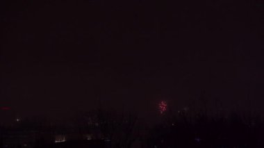 Yeni yılı kutladığımız gün, Lublin 'in panoramasının üzerinde havai fişekler. Periyodik olarak alevlerin ve diğer havai fişeklerin parlak ışıkları karanlık arka planda parlıyor. Kutlama ve binlik