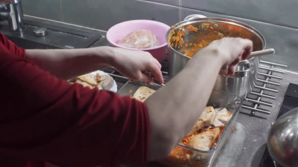 Anordnen gebratener Fischstücke auf gekochtem, gehacktem Gemüse zu einem Gericht namens Fisch auf Griechisch. Dicke Stücke Kabeljau geschnitten. Hausmannskost. — Stockvideo