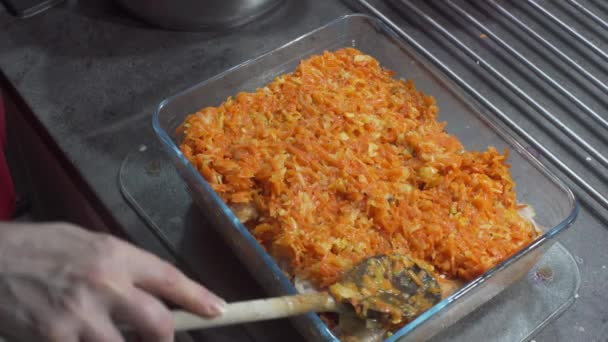 Colocar la última capa de muchas verduras, y sobre todo, cortar y cocinar zanahorias. Un plato llamado pescado en griego. Cocina casera. La etapa final de preparación del plato. Marco de primer plano. — Vídeos de Stock