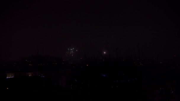 Fireworks above the panorama of Lublin on the day of celebrating the new year. Periodically bright lights from flares and other fireworks flash against a dark background. Celebration and a grand — Stock Video