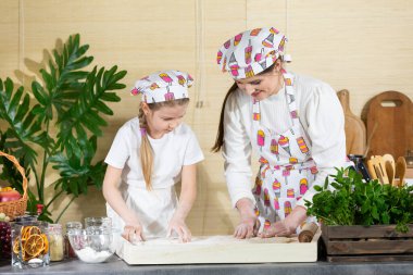 Anne ve kızı birlikte pastayı fırlatıp, elleriyle okşayacaklar. Anne ve bebek mutfakta hamuru birlikte yapıyorlar..