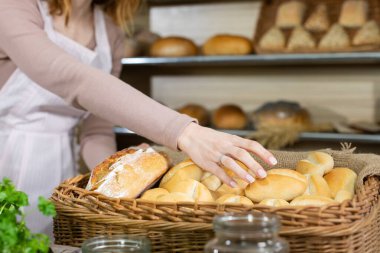 Taze ekmek yakışıklı bir fırıncı tarafından teslim edilirken çekici satıcı kadın bir çörek sunuyor. Çok nesilli gelenekleri olan aile pastanesi..