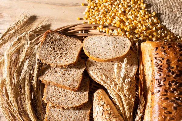 The shop counter is decorated with various types of wheat and rye bread and ears of ripe rye and wheat. Thin slices of bread. — Stock Photo, Image