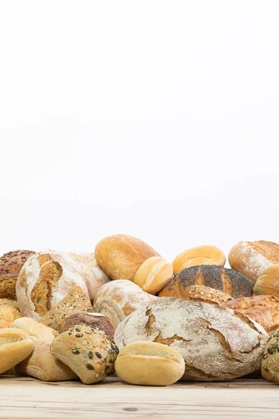 Many kinds and kinds of bread collected in one place on a wooden old shop counter as a decoration for a traditional bakery. White background from the top for self-completion. — Stock Photo, Image