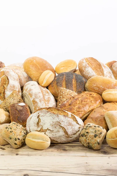 Many kinds and kinds of bread collected in one place on a wooden old shop counter as a decoration for a traditional bakery. White background from the top for self-completion. — Stock Photo, Image