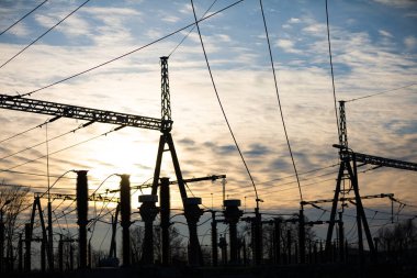 Günbatımında yüksek güçte elektrik iletim istasyonu yüklenmiş bir yıldırım koruma sistemiyle..