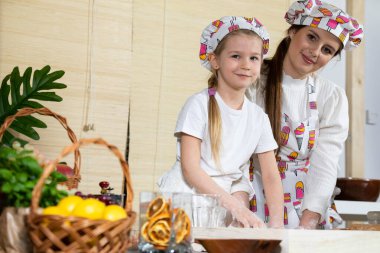 Son aşamalardan birinde, anne ve kızı pizza olarak servis edilecek bir keki yoğurup yoğururlar. Anne ve bebek mutfakta hamuru birlikte yapıyorlar..