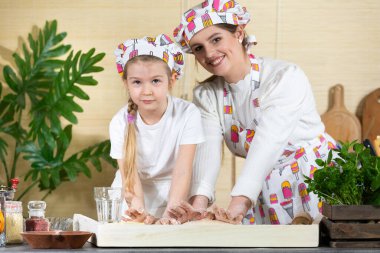 Son aşamalardan birinde, anne ve kızı pizza olarak servis edilecek bir keki yoğurup yoğururlar. Anne ve bebek mutfakta hamuru birlikte yapıyorlar..